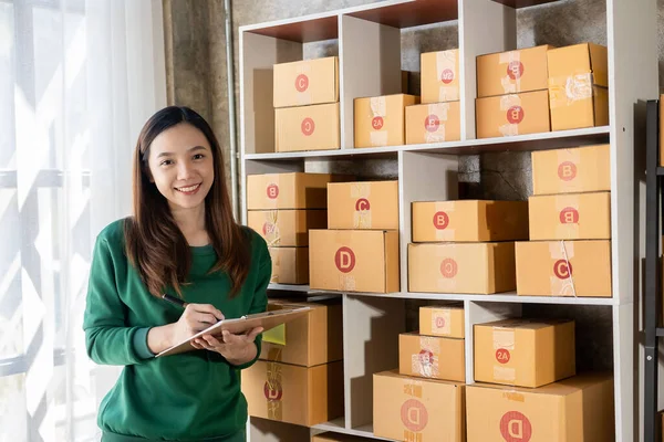 Attractive Asian businesswoman checking item before sending it to customer small business owner check Parcel box delivery, online marketplace, SME e-commerce, marketing concept