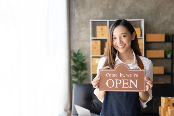 Small business owner, sme, beautiful girl holding a sign to open the shop Portrait of an Asian female barista owner SME business concept,