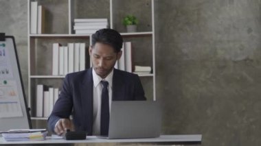 İşadamı iş stratejisi muhasebe istatistikleri hakkında rapor vermek için şirket laptopunu kullanıyor. Ofisteki veri grafik analizi hakkında ciddi gelişme raporu.
