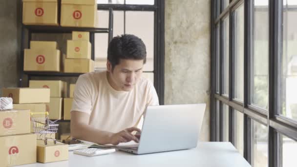 Mladý Asijský Podnikatel Tričku Mezi Balíky Práce Domácí Kanceláři Notebookem — Stock video