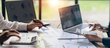 Cropped image of business team discussing financial planning graph and company during budget meeting in office room. Horizontal image.