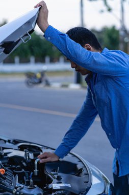 Man checking his car engine, professional mechanic working on car engine, car repair service. The concept of checking the readiness of the car before leaving.
