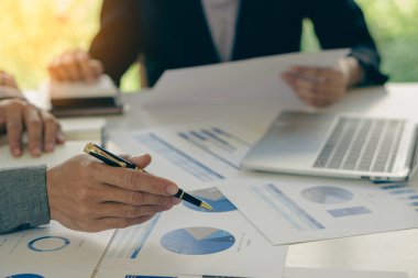 Businessmen meeting using laptop computers calculator stock market chart paper for computational analysis company financial plans and improve the quality of discussion meetings.