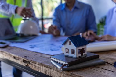 Civil engineer team meeting with helmet and typing in house design on construction site, foreman, project manager, industry engineer team work Architect, foreman, professional team