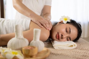 beautiful woman in spa environment Asian woman in bathrobe on sofa as she spas herself with massages and facials at home. concept of beauty