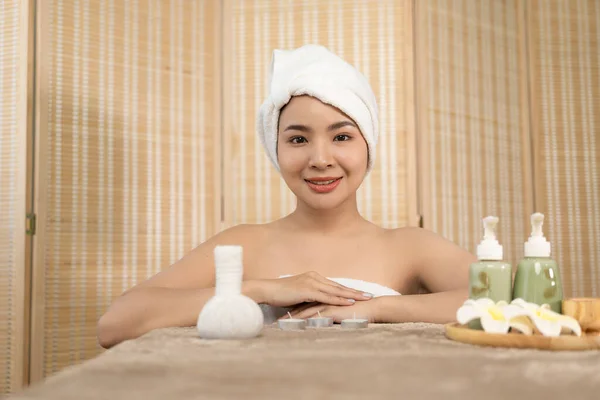 beautiful woman in spa environment Asian woman in bathrobe on sofa as she spas herself with massages and facials at home. concept of beauty