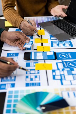 Asian young people working together on mobile application software design project. Brainstorming. Internet technology. smartphone web designer creative teamwork concept vertical image