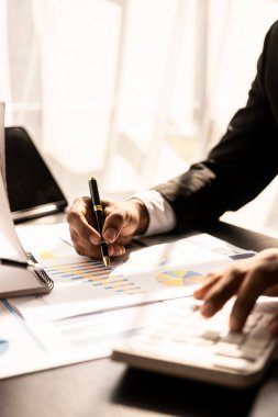 Male businessman hands working on financial documents in modern office doing accounting analysis report real estate investment information Vertical view of the financial and tax system.