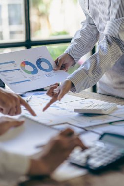 Businessmen meeting using laptop computers calculator stock market chart paper for analysis Quality improvement plan in business idea discussion meeting vertical image