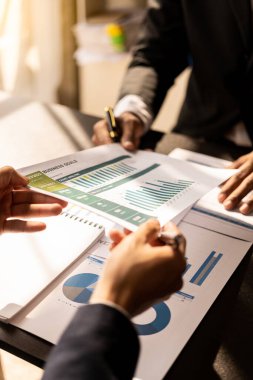 Businessmen meeting using laptop computers calculator stock market chart paper for analysis Quality improvement plan in business idea discussion meeting vertical image