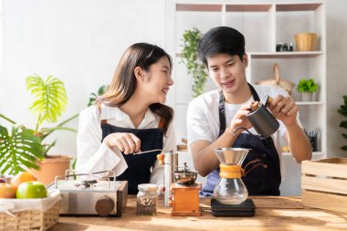 Beautiful young couple preparing breakfast together in modern kitchen Kitchen man preparing food with bread and fruit in cozy kitchen in cozy house.
