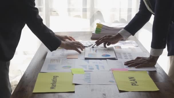 Два Бізнесмени Костюмах Обговорюють Проект Папері Графіками Діаграмами Показуючи Фінансові — стокове відео
