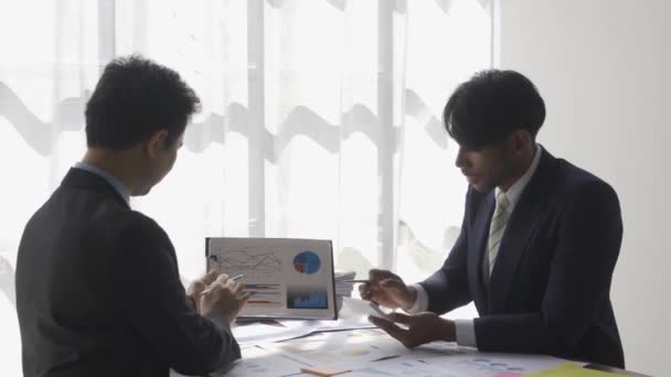 Два Бизнесмена Костюмах Обсуждают Проект Бумаге Графиками Графиками Указание Финансовые — стоковое видео