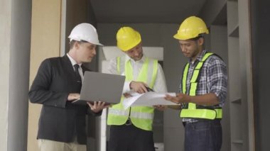 Architect discussing blueprints on laptop with construction manager Engineer talking to contractor consultant on construction site about construction project and business workflow in new building