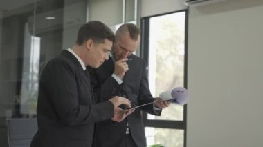 İki heyecanlı finans yöneticisi dizüstü bilgisayarlarına bakıyor ve başarılı anlaşmayı kutluyorlar. İş dünyasının en iyi yöneticisi VDO 4k 'yi kazanmaktan memnun.