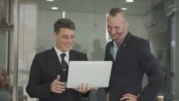 两位兴奋的高级财务主管拿着笔记本电脑 看着那些庆祝交易成功的文件 同事的高级经理为赢得了Vdo 4K业务而高兴 — 图库视频影像