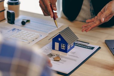 Loan officers recommend homes to clients after signing a real estate contract with an approved mortgage request regarding the offer of mortgage interest rates and home insurance.