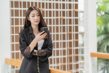 Beautiful Asian woman using smart phone to surf social media, surf the net, chat with friends and play online games. online shopping load the application on the internet