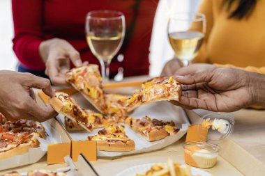 Group of employees eating Italian pizza Hand picked pizza in a lunch or dinner shop. Tasty seafood gravy sauce. Traditional Italian fast food on wooden table with drinking wine.