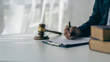 Male lawyer in suit or judge working on documents legal and justice advice Businessman working at law office and squatting with court scales and hammer