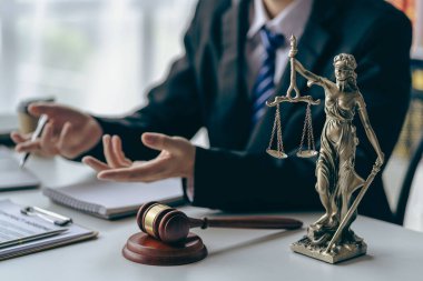 Male lawyer in suit or judge working on documents legal and justice advice Businessman working at law office and squatting with court scales and hammer