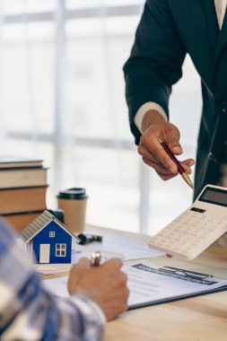 Real estate agents offer to sell houses and land to their clients. Offer a model home make a house contract Bank employees recommend home loans and fire with financial approval. vertical image