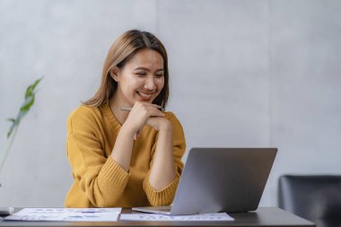 Asian female entrepreneur who uses a calculator to do calculations. Business performance documents of accounting firms, auditors, freelance, finance and investment Tax calculation and budget each year