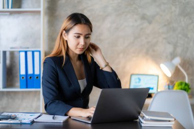Asian female entrepreneur who uses a calculator to do calculations. Business performance documents of accounting firms, auditors, freelance, finance and investment Tax calculation and budget each year