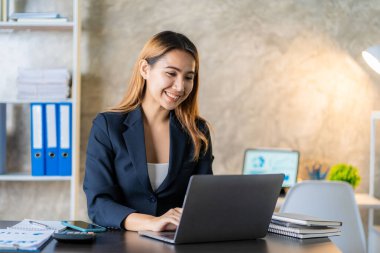 Asian female entrepreneur who uses a calculator to do calculations. Business performance documents of accounting firms, auditors, freelance, finance and investment Tax calculation and budget each year