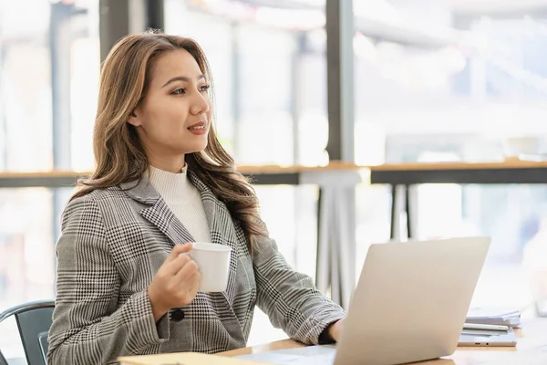 stock image Asian female entrepreneur who uses a calculator to do calculations. Business performance documents of accounting firms, auditors, freelance, finance and investment Tax calculation and budget each year