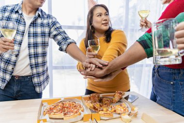 Group of employees eating Italian pizza Hand picked pizza in a lunch or dinner shop. Tasty seafood gravy sauce. Traditional Italian fast food on wooden table with drinking wine.