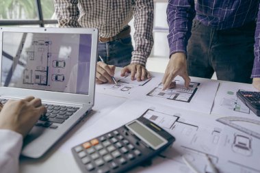 Profesyonel iş ortaklarından oluşan bir ekip elinde kalem tutarak mali grafik belgesini işaret ediyor, analiz ve strateji danışmanlığını hesaplıyor. Toplantı, ofiste beyin fırtınası, takım çalışması konsepti..