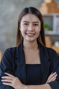 Evde kutularla çalışan, siparişleri kontrol eden ve paketleri teslim etmeye hazırlanan Asyalı genç kadın, KOBİ çevrimiçi iş konsepti