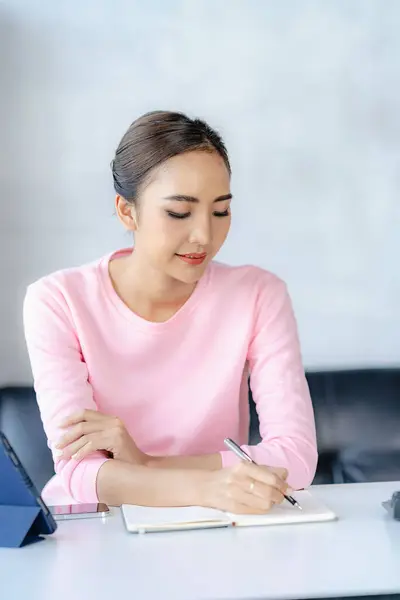 stock image Asian girl working with tablet and notebook at home, online work concept