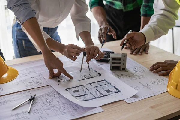 Engineers work as a team with blueprints for architectural plans. Engineer sketching construction project concept with architect equipment Architect and foreman talking at table