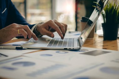 Vergiler ve harcamalarla ilgili ev finansmanı üzerinde çalışan bir iş adamı dizüstü bilgisayarda klavye kullanıyor