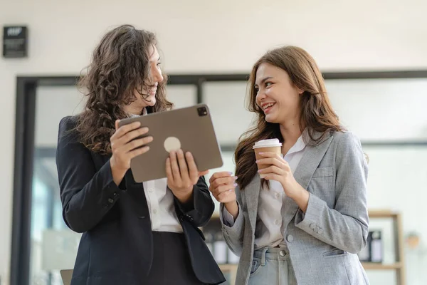 Stock image Two cheerful businesswoman working using digital tablet at conference table with documents working at office Business colleagues for real estate project discussion meeting