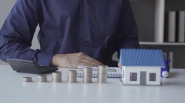 Bir yığın para ve ev, sigorta konsepti iş adamı emlak sigortası için şemsiye dağıtıyor..