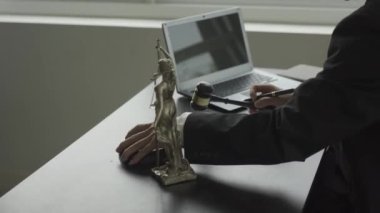 Kontrat belgeleri, dizüstü bilgisayar ve çekiç adaletsizliği ile çalışan bir avukat.