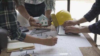 Danışmanlık mühendisleri ve çalışma planlarıyla toplantı mimarlar veya mühendisler ev tasarlar, çizimleri değiştirir, inşaat projeleri oluşturur ve müşterilerin ihtiyaçlarına eklenir.