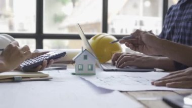 Danışmanlık mühendisleri ve çalışma planlarıyla toplantı mimarlar veya mühendisler ev tasarlar, çizimleri değiştirir, inşaat projeleri oluşturur ve müşterilerin ihtiyaçlarına eklenir.