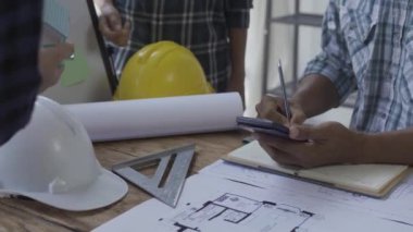 Danışmanlık mühendisleri ve çalışma planlarıyla toplantı mimarlar veya mühendisler ev tasarlar, çizimleri değiştirir, inşaat projeleri oluşturur ve müşterilerin ihtiyaçlarına eklenir.