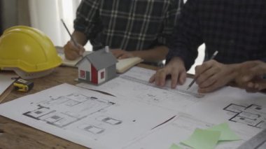 Danışmanlık mühendisleri ve çalışma planlarıyla toplantı mimarlar veya mühendisler ev tasarlar, çizimleri değiştirir, inşaat projeleri oluşturur ve müşterilerin ihtiyaçlarına eklenir.