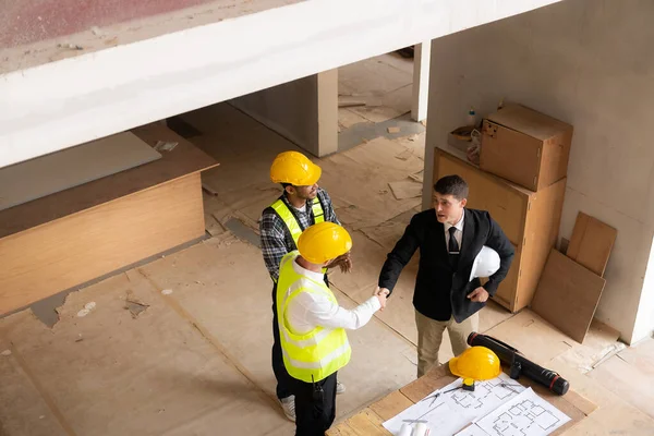 İnşaatta mühendislerle tokalaşan işadamı, inşaat alanı yenileme konsepti, proje için işyerini denetleyen mimar mühendisi