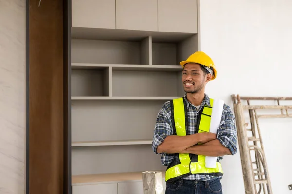 身穿工作服的年轻男性工程师承包商站在建筑工地的画像 — 图库照片