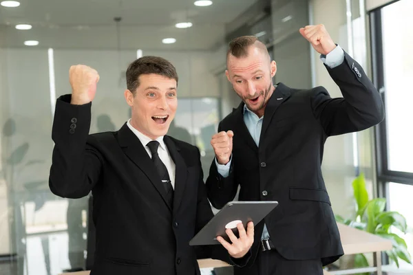 Twee Knappe Jonge Zakenmannen Pakken Met Tablet Vieren Enthousiast Succes — Stockfoto