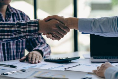 Ofiste başarılı bir iş birliği içinde el sıkışan iki kendine güvenen işadamı, emlak sektöründe başarılı bir işbirliği ve irtibat kuruyor.