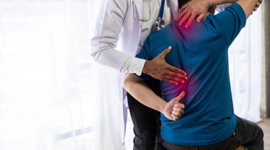 Genç Asyalı adam fizyoterapi yapıyor ve rehabilitasyon merkezinde omuz ve bacaklarla kas ağrısından tavsiye istiyor..