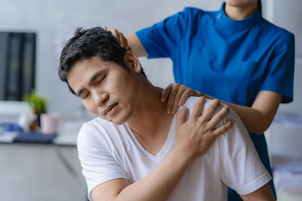 stock image Young Asian man doing physiotherapy and seeking advice from muscle pain with shoulder, limbs in rehabilitation center.