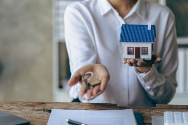 Ev anahtarlarını teslim etmek ve ev tanıtmak Satış temsilcileri müşterilere anahtarları teslim etmek Yeni alıcılar ev kredileri ve sigorta sözleşmeleri onaylanır.